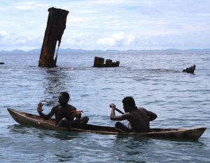 Locals paddling near the remains of the Kinugawa Maru