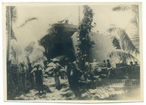 Trucks being driven off LST 485 on Stirling Island