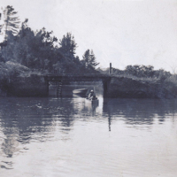 My mother in the family dinghy on the creek